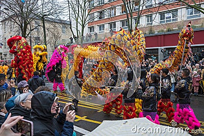 Chinese New Year, parade of dragon dance celebration the Dragon year in the thirteen district of Paris under a rain Editorial Stock Photo