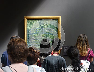 Paris, France - August 29, 2019: Crowd of visitors near the Water-Lily Pond, Symphony in Green 1899 by Claude Monet painting in Editorial Stock Photo