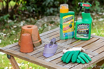Paris, France - August 15, 2018 : Herbicide on a wooden table in a french garden. Roundup is a brand-name of an herbicide containi Editorial Stock Photo