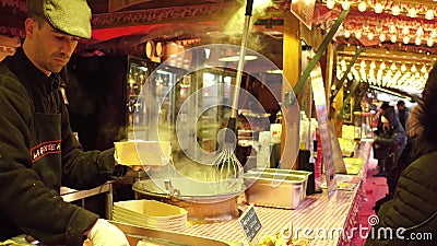 PARIS, FRANCE - DECEMBER, 31. Christmas and New Year market fastfood stall vendor. Serving traditional melted cheese Editorial Stock Photo