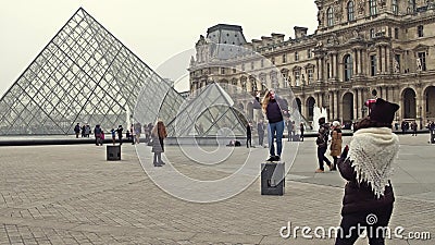 PARIS, FRANCE - DECEMBER, 31, 2016. Female tourists posing and making photos near the Louvre, famous French museum Editorial Stock Photo