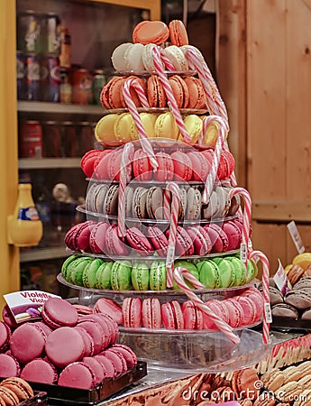 PARIS, FRANCE-DECEMBER 7, 2013: A Pyramid of of colorful sweet macaroons with caramel sticks on the showcase of the Christmas Editorial Stock Photo