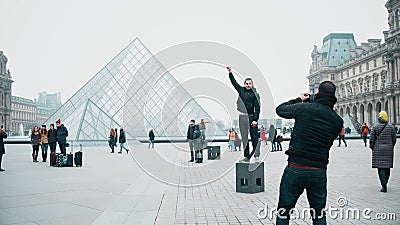 PARIS, FRANCE - DECEMBER, 31, 2016. Tourists posing and making photos near the Louvre, famous French museum. Popular Editorial Stock Photo