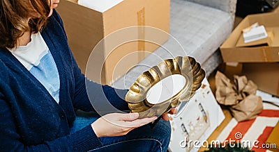 Side view of woman unboxing new Zara Home product - beautiful vintage forged Editorial Stock Photo