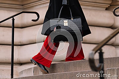 Paris, France - January, 23, 2023: man wears black red pants and Thom Browne alligator bag Editorial Stock Photo