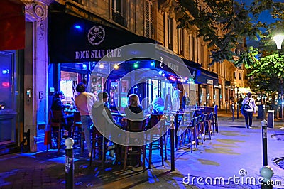 Paris, France, June 2022. Fascinating night shot of one of the many cafes that we can see along the streets of the center. People Editorial Stock Photo