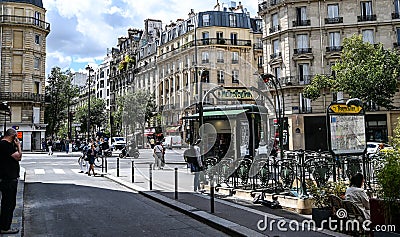 Paris,France.June 2022. In the historic center, a beautiful view of a metro station with a distinctive vintage sign. People on the Editorial Stock Photo