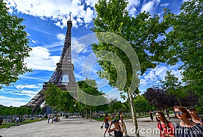 Paris, France, June 2022. In the large gardens of the Champ de Mars people relax in the greenery enjoying the view of the Eiffel Editorial Stock Photo