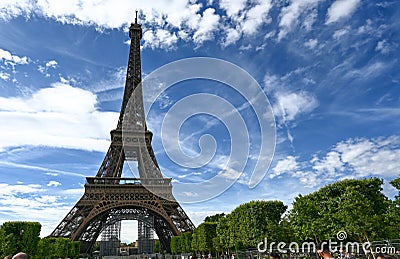 Paris, France, June 2022. In the large gardens of the Champ de Mars people relax in the greenery enjoying the view of the Eiffel Editorial Stock Photo