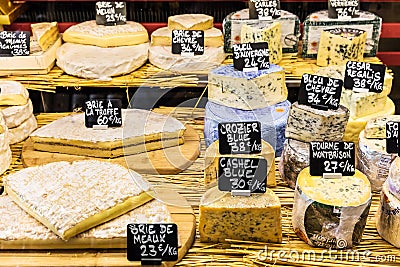Different cheeses on the counter of a small store at the Aligre Editorial Stock Photo
