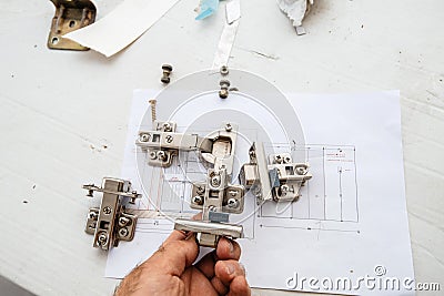 POV holding looking at new Ikea drawer hinge with a schematic drawing Stock Photo