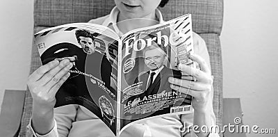 Woman reading Forbes France billionaires list education Editorial Stock Photo
