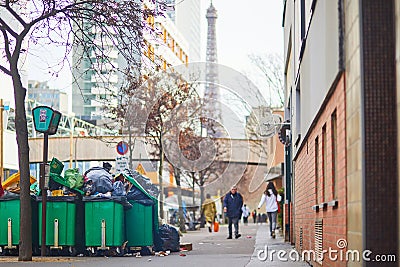 Paris, France - March 16, 2023: Messy streets with overfull garbage bins during binmen strike in Paris, France Editorial Stock Photo