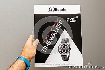 Man holding against gray background a Le Monde newspaper supplem Editorial Stock Photo
