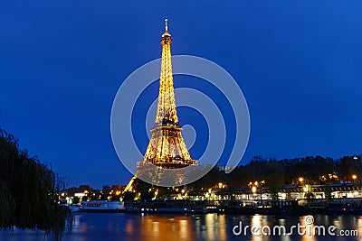 The night view of the Eiffel Tower, famous monument glowing at dusk located at bord of Seine river. Paris.France. Editorial Stock Photo