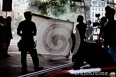 Film set production, near Notre-Dame Cathedral, director, operator, ARRI camera, trolley cart, artificial fog, actors Editorial Stock Photo