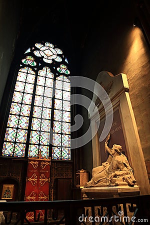 Paris, France - October 28, 2018: Interior of Notre Dame de Paris. Small altar with ancient statue of saint and stained glass Editorial Stock Photo