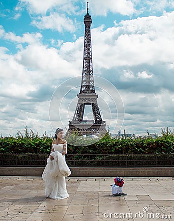 Asian bride waiting to be photographed for her trash the dress session with the Eiffel Tour Editorial Stock Photo