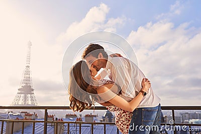 Paris, love and couple together for a kiss, romantic time or balcony of apartment, hotel with Eiffel Tower in background Stock Photo