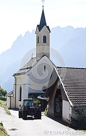 Parish church and tractor in Dorfl, Austria Editorial Stock Photo