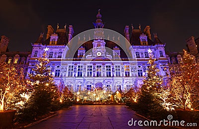 Parisian City Hall decorated with Christmas trees for winter holidays at night. Winter travel and tourist attractions in Stock Photo