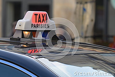 Parisian Taxi sign and car circulating with customer in the Paris streets Stock Photo