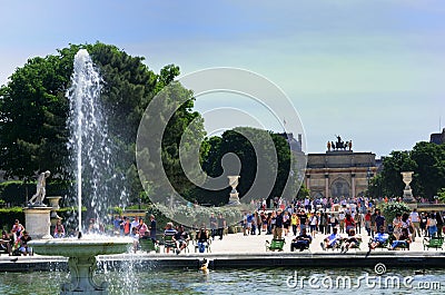 Parisians relaxing at Tuleries with fountain and lourve in background Editorial Stock Photo