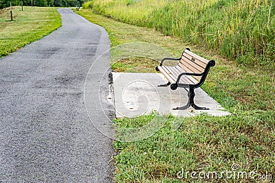 Park Bench by a Walking Path Stock Photo