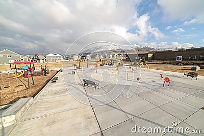 Park and childrens playground against homes and snow capped mountain in winter Stock Photo