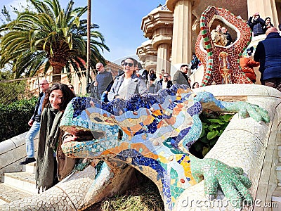 People pose for photographs in front of the popular el drac (the dragon) ceramic statue in Park Guell, Barcelona, Spai Editorial Stock Photo