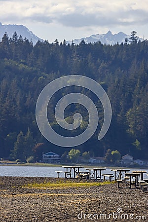 park tables near a lake at the base of a mountain Stock Photo