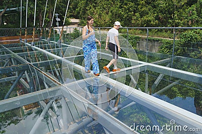 Tourists enjoying the amazing glass floor Bridge high above the jungle Stock Photo