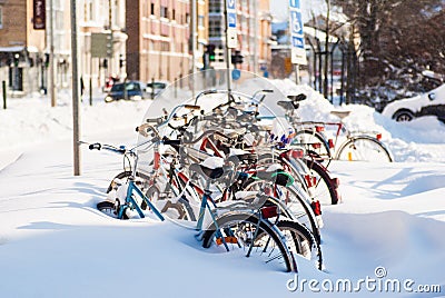 Parked bicycles covered in snow after heavy snowfall. Editorial Stock Photo