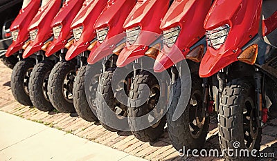 parked rental moped in row, lower view. parked rental moped red color. parked rental moped Stock Photo