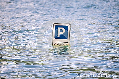 Parking cars road sign partially submerged in a flood. Stock Photo