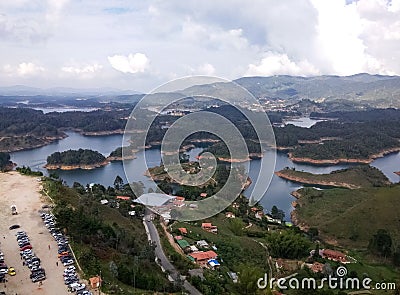 Parking with cars and tourists arriving at the Guatape lakes and the PeÃ±ol rock Stock Photo