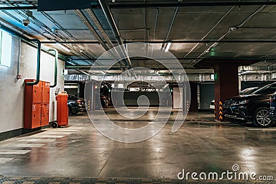 Parking Garage, Illuminated Underground Car Park Lots under modern Mall with Vehicles Stock Photo