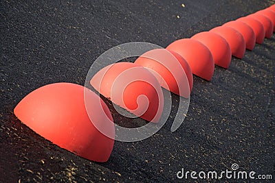 Parking limiters - red concrete hemispheres on asphalt. Stock Photo