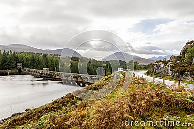 Parking near a scenic arch curved Laggan Dam structure in Scotland Editorial Stock Photo