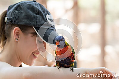 Parrot sits on the hand of a young woman at the Australian Zoo Gan Guru in Kibbutz Nir David, in Israel Editorial Stock Photo