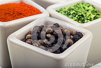 Parsley, red pepper powder and crushed pepper in ceramic cups. Stock Photo