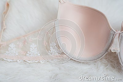 Part beige bodice with lace on white fur. Inner side. Underwear, fashion concept. Close up Stock Photo