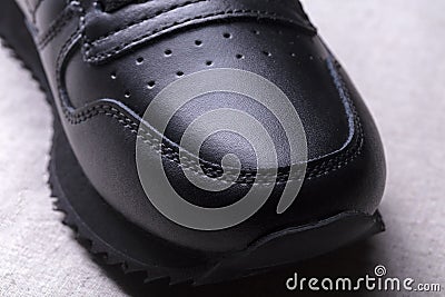 Part of a black leather boot. Stock Photo