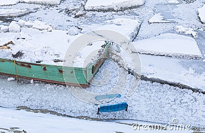 Part of boat and plastic chair on frozen river Danube Stock Photo