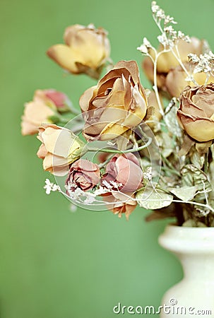 A part of a bouquet of autumn brown colored artificial roses on green background with copy space. Stock Photo