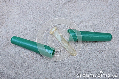 part of a brown broken pipette and an open green plastic case parts Stock Photo