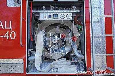 Part of equipment of a firetruck compartment: water pump, control panel, manometers and hose joined Editorial Stock Photo