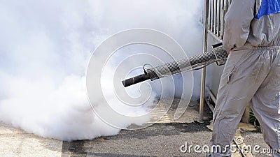 health personal worker using fogging machine spraying chemical to eliminate mosquitoes and prevent dengue fever Stock Photo