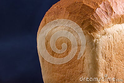 Part of a loaf of white bread on a blue background Stock Photo