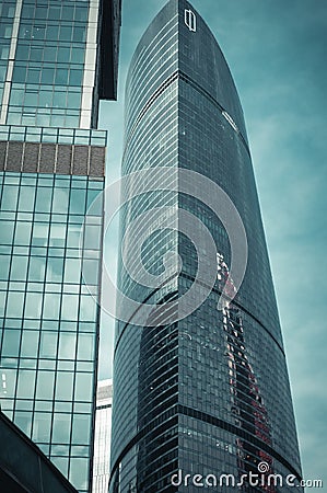 Part of modern glass skyscraper in the morning light. Perspective view of commercial building on th background of clear blue sky Editorial Stock Photo